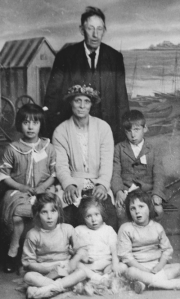 I think this is the Prince Family. The lady in the middle is probably Annie Prince, the grandmother I never knew. I thinh she is with Gladys and Jim, with Joan, Ruby and Ellen sitting in the front row. I presume the man is Mr Prince.